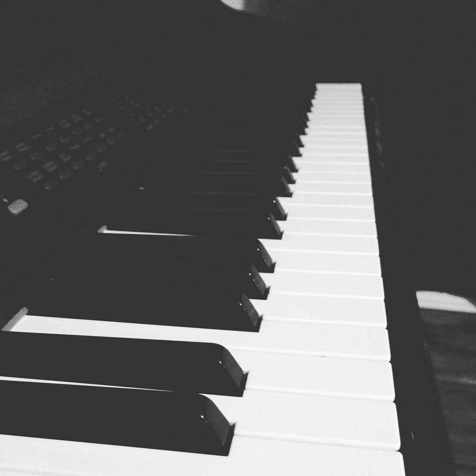 Black-and-white close-up of piano keys stretching away from the camera.